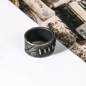 Close-up of vintage stainless steel ring with unique stitched pattern and distressed finish