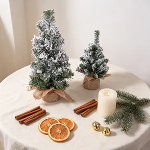 Detail of snowy miniature Christmas trees on a festive tabletop with holiday decor.