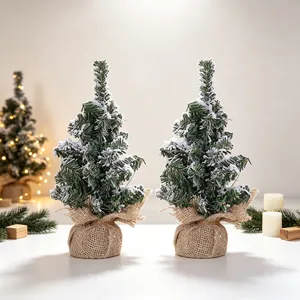 Two mini frosted Christmas trees with burlap bases for elegant festive tabletop decoration