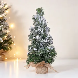 Detailed view of mini artificial flocked Christmas tree featuring rustic burlap base