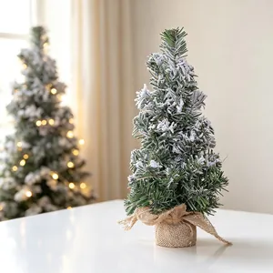 Detailed macro view of a mini snow-covered artificial Christmas tree on a table.