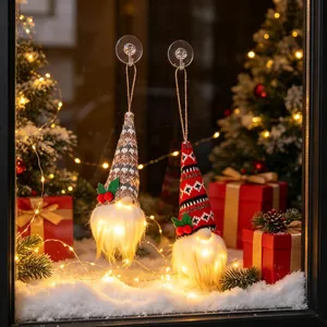 Pair of glowing Christmas gnome ornaments with knitted hats for window hanging decor.