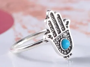 Detailed close-up of a retro silver Hamsa hand ring featuring a central blue bead.