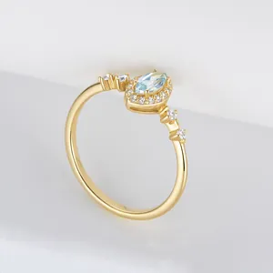 Close-up detail of a gold-plated sterling silver ring with sky blue topaz and zircons