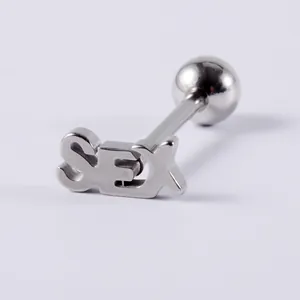 Close-up of stainless steel tongue ring with 'SEX' letter engraving and ball end.