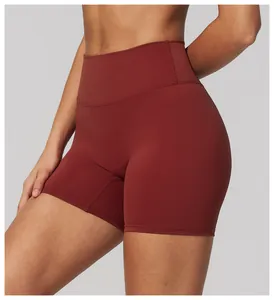 Close-up detail of high-waist burgundy yoga shorts on model for fitness workout