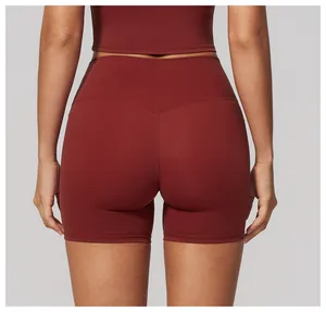 Macro view of professional high-waisted burgundy yoga shorts showing seamless texture