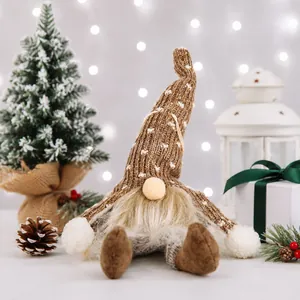 Detail shot of a brown knitted Christmas gnome plush with glowing lights and bokeh background