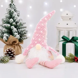 Macro detail of a handmade pink knitted Christmas gnome plush with a fluffy white beard.