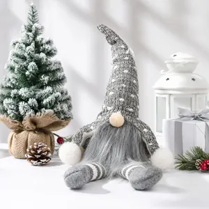 Detailed view of a grey knitted Christmas gnome plush toy sitting in a festive scene.