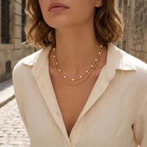 Elegant French style double-layered necklace with pearls and gold beads worn by a model