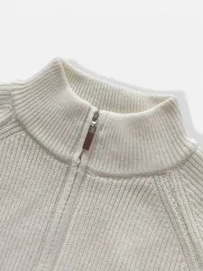 Close-up detail of white stand-collar knit sweater with premium metal zipper texture