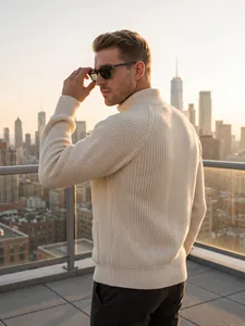 Back view of a man in a cream ribbed knit cardigan with a stand collar on a rooftop.