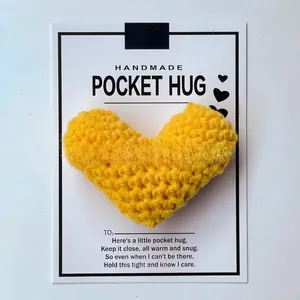 Handmade yellow crocheted heart pocket hug attached to a minimalist white greeting card