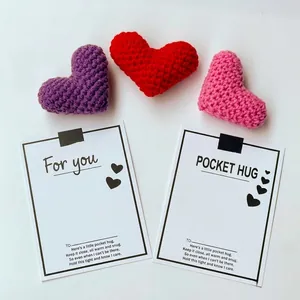 Close-up of handmade crocheted hearts in purple, red, and pink with Pocket Hug gift cards