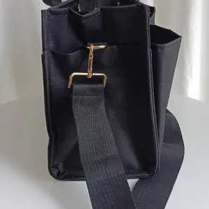 Large capacity black mommy bag with multi-compartment design and gold hardware