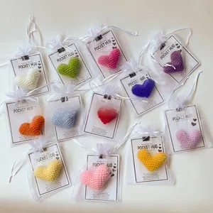Handmade colorful crocheted heart pocket hugs in white mesh bags with greeting cards