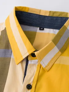 Détail du col et des boutons d'une chemise pour homme en coton à carreaux jaunes