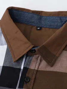 Vue macro détaillée du col et des boutons d'une chemise en coton à carreaux marron.