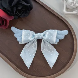Vue détaillée d'une jolie pince à cheveux nœud bleu clair avec ailes en peluche Lolita.