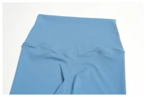 Close-up detail of high-waisted yoga leggings showing V-shaped back seam and blue fabric.