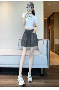 Model wearing a dark grey high-waist cargo skort with large pockets and drawstring.
