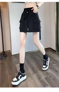 Detail view of a high waist black cargo skort with utility pockets and a drawstring waist