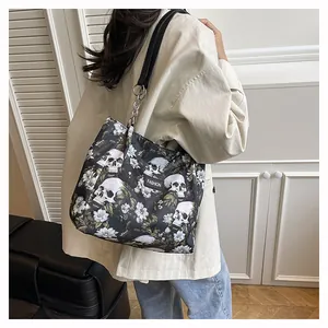 Detail view of a large capacity tote bag with skull and flower prints worn by model