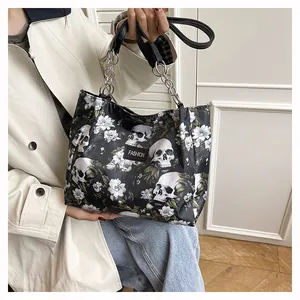 Detailed view of the edgy skull and floral print tote bag being held by a model