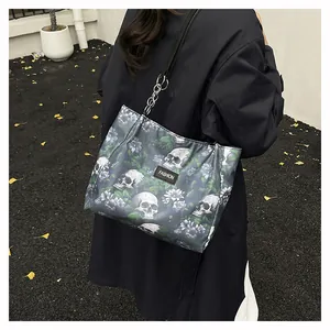 Stylish skull and floral print tote bag shown being worn by a model in a street setting