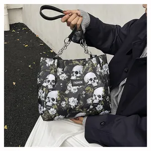 Close-up detail of stylish skull and floral print tote bag with silver chain straps