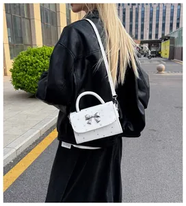 Chic white crossbody handbag for women featuring a stylish silver bow and star pattern.