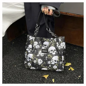 Close-up of a fashionable black tote bag featuring skull and floral prints with chain straps