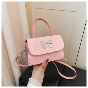 Close-up detail of a sweet pink crossbody handbag with silver bow and star decorations