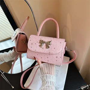 Stylish pink mini handbag with metallic bow and star pattern, chic crossbody style.