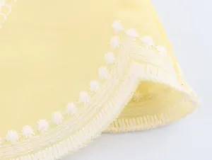 Gros plan sur la broderie florale blanche d'un haut jaune pour femme de style français