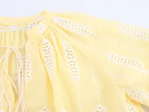 Gros plan détaillé d'un chemisier jaune de style français avec broderie anglaise.