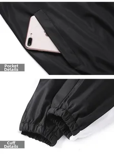 Détails du survêtement noir montrant la poche zippée et les poignets élastiqués