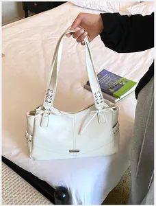 Vue détaillée d'un sac à main blanc en cuir PU avec lanières à lacets sur un lit