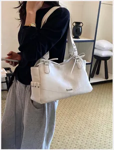 Modèle portant un élégant sac cabas en cuir PU blanc avec détails de bandoulière lacée