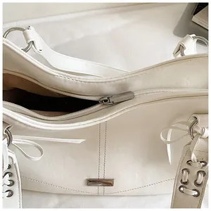 Gros plan de la fermeture éclair et des finitions métalliques d'un sac cabas blanc en PU.