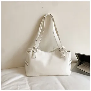 Vue minimaliste d'un grand sac cabas blanc en cuir PU posé sur une surface neutre