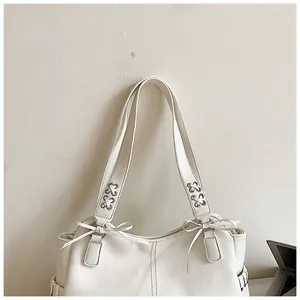 Vue détaillée des poignées d'un sac cabas en PU blanc avec nœuds et lacets décoratifs