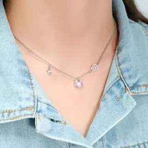 Vue détaillée d'un collier en argent avec des breloques chat et patte sur le cou d'un mannequin.