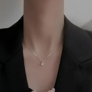 Gros plan d'un élégant collier avec pendentif muguet argenté sur le cou d'un mannequin