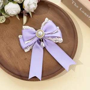Detail of lavender lace bow hair clip with elegant pearl pendant