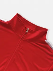 Macro detail view of a red men's athletic jacket stand collar and silver metal zipper puller