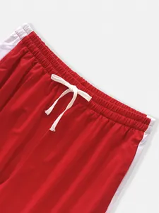 Detailed macro view of the white drawstring on red jogging pants with white side stripes