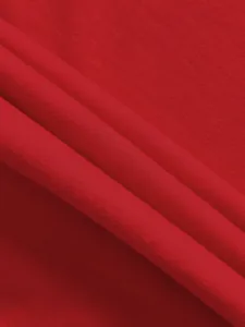 Detailed close-up of soft red jersey fabric texture showing fine knit and natural drape