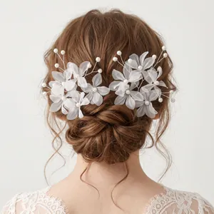 Back view of bridal hair styling with white fabric flower and pearl hairpins